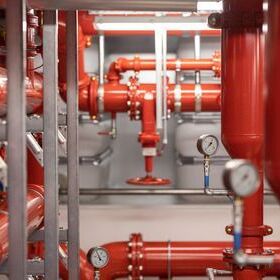 Das rote Rohrnetz einer Sprinkler-Nassanlage mit Druckmessern