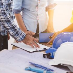 Engineers with clipboard and helmets