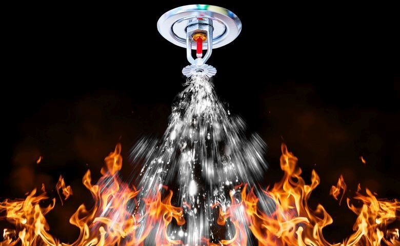 Sprinkler in Aktion und löscht Feuer mit seinem Wasser